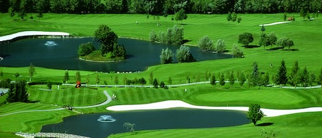 A golf course with multiple ponds, sand bunkers, and a bridge.