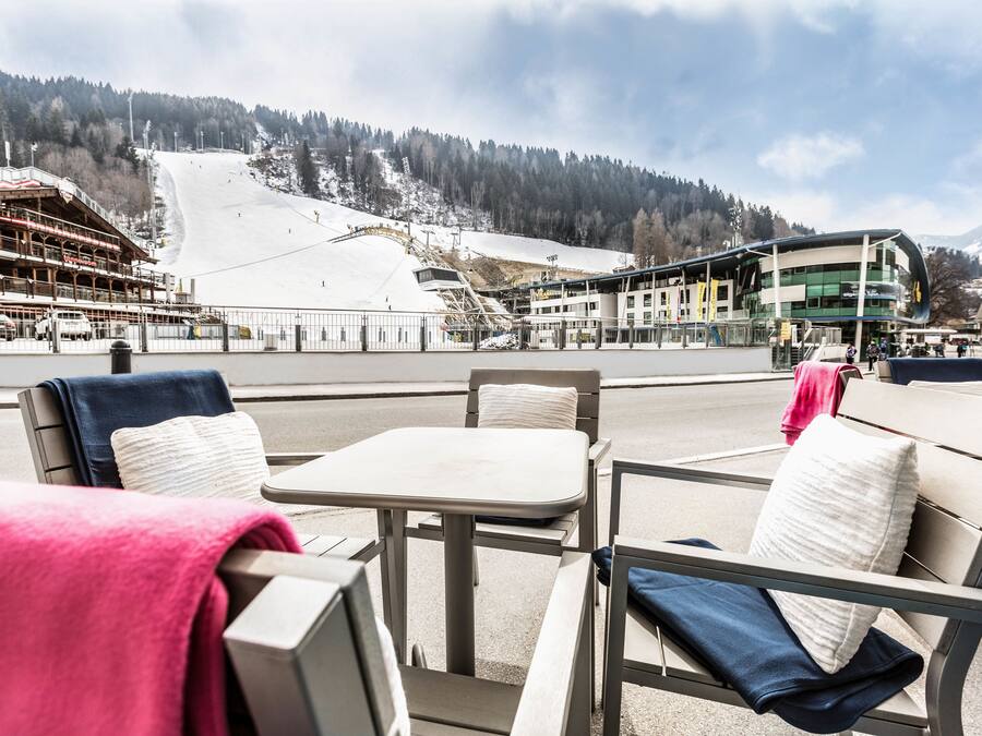 Un restaurant avec une terrasse offrant une vue sur une piste de ski.