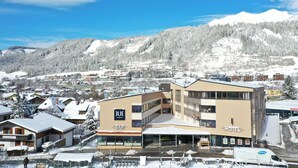 Ein Hotel mit Bar und Restaurant, umgeben von schneebedeckten Gebäuden und Bergen.