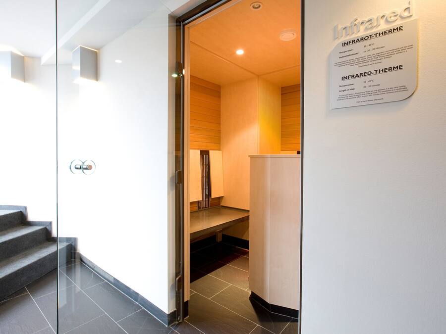 A modern interior with a glass door leading to a kitchen area.