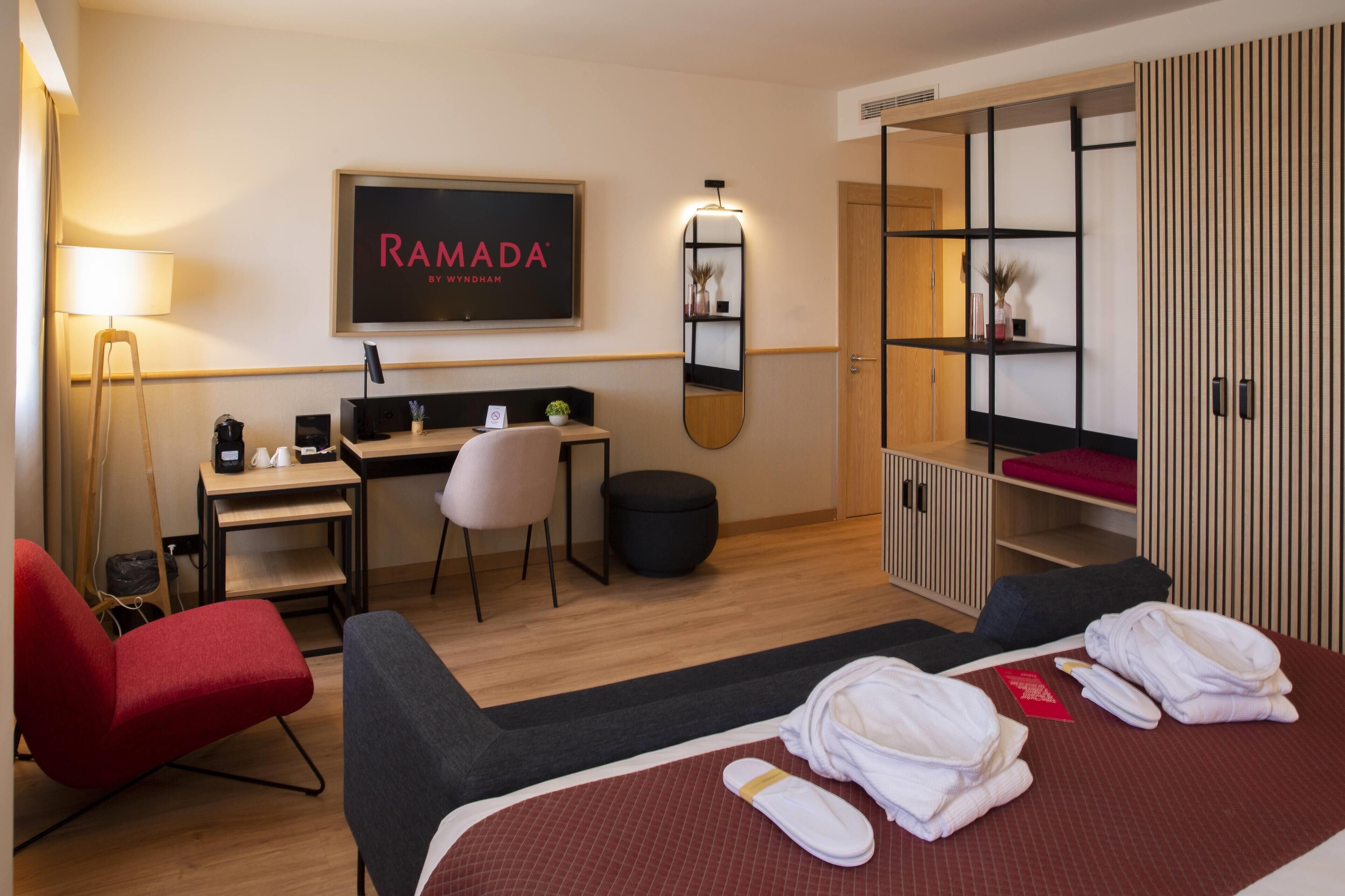 Ein Hotelzimmer mit Bett, Schreibtisch, Stuhl, Kleiderschrank und Spiegel.