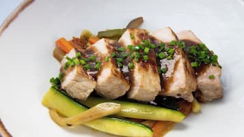 A plate of sliced meat with vegetables and green onions.
