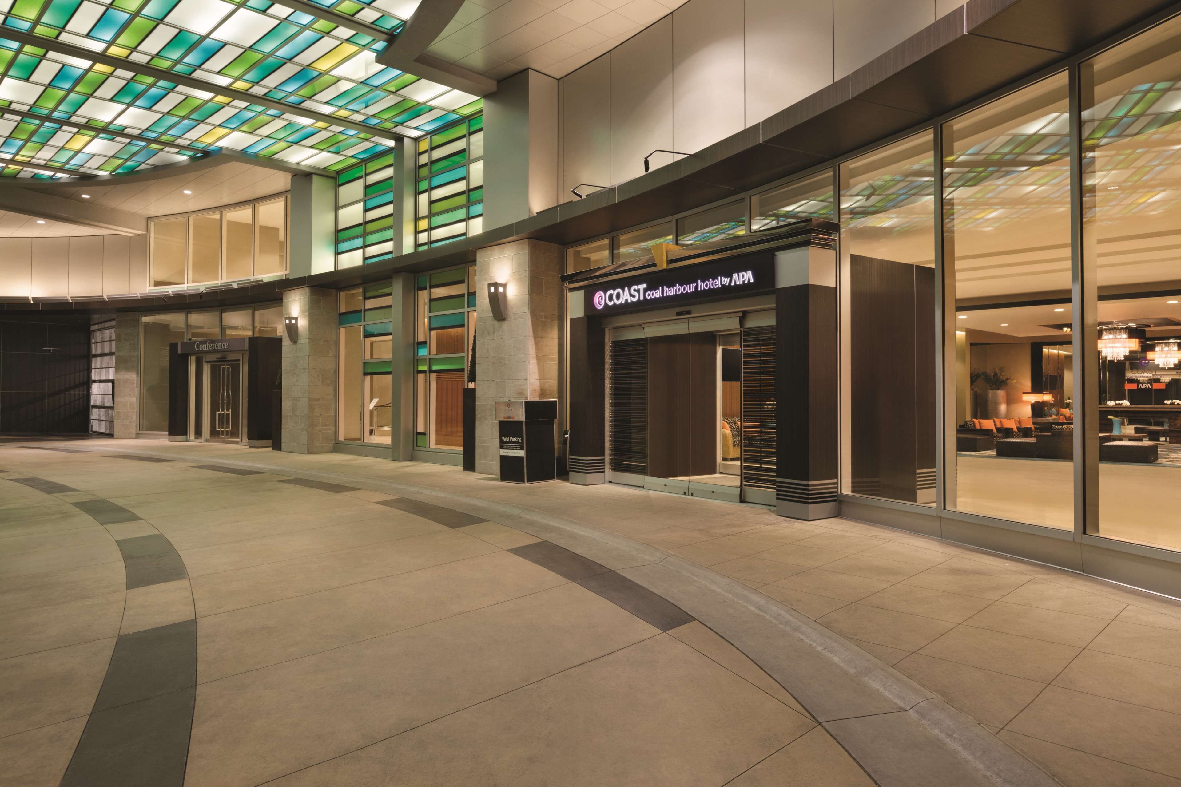 A hotel interior with a modern design, large windows, and a distinctive ceiling.