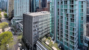 A high-rise urban building complex with modern architecture, including glass facades and a prominent blue logo on one building.
