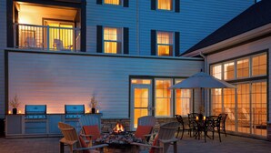 A patio with a fire pit, outdoor seating, and a grill area. - Residence Inn by Marriott Gravenhurst Muskoka Wharf (Gravenhurst)