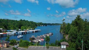 A marina with boats docked, a parking area, and a small building. - Residence Inn by Marriott Gravenhurst Muskoka Wharf (Gravenhurst)