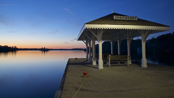 Un quiosco llamado 'Gravenhurst' junto a un lago tranquilo al anochecer.
