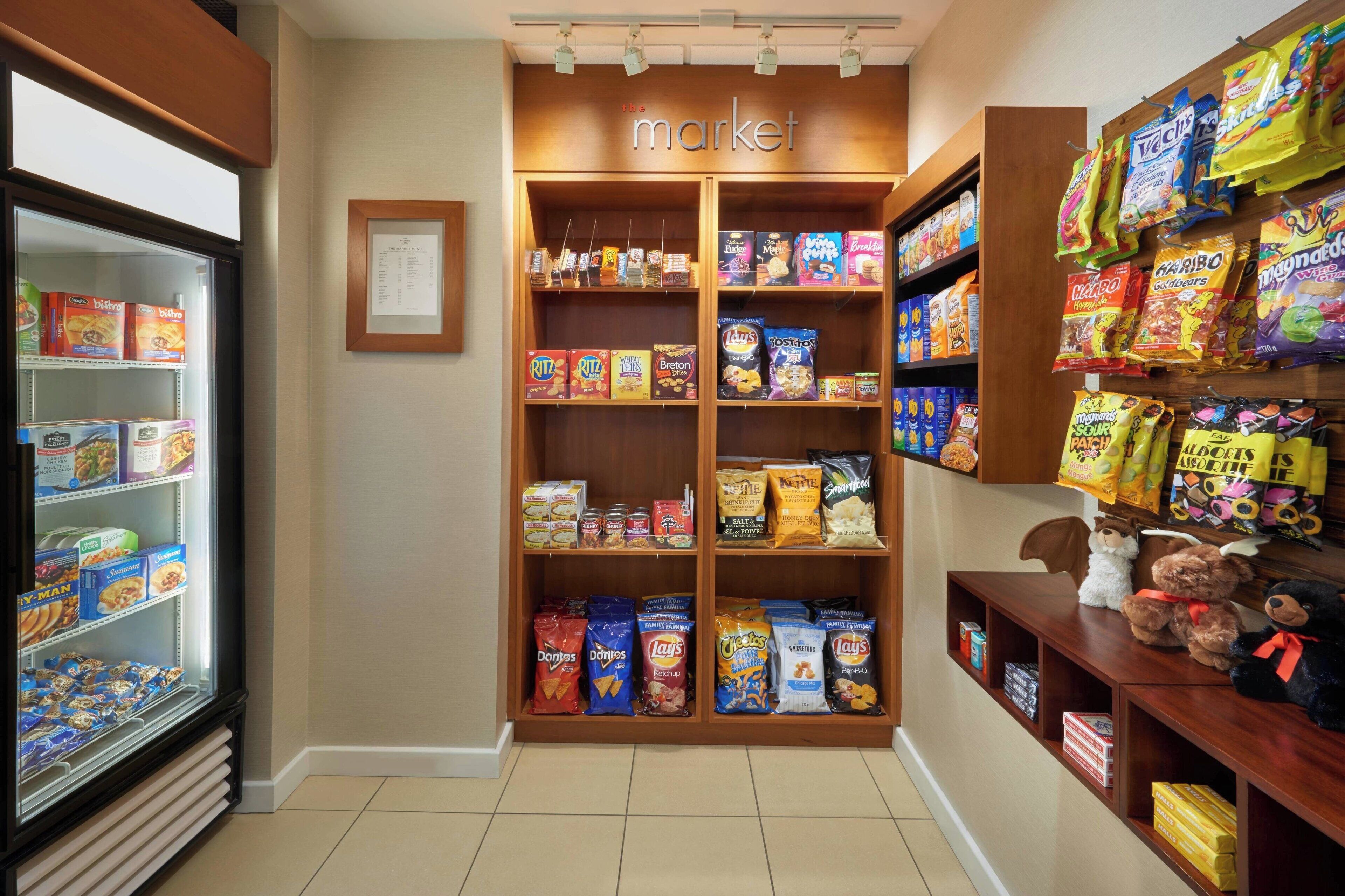 A snack display area with various packaged snacks and a refrigerated section.
