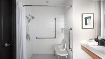 Un baño moderno con ducha, inodoro, banco y lavamanos con toallero.