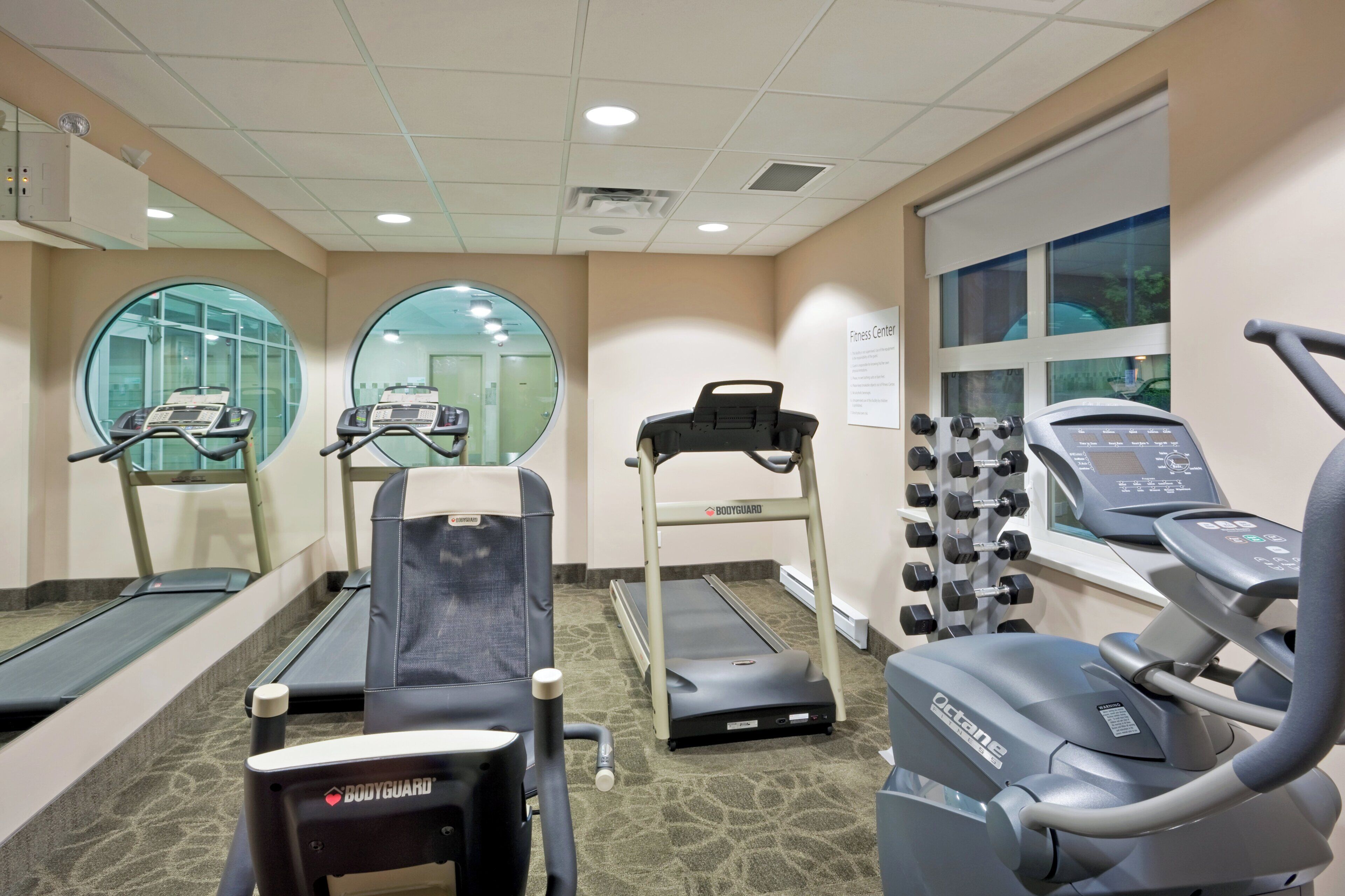 A fitness center with treadmills, a stationary bike, and a weight bench.