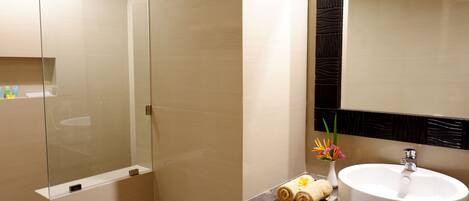 A bathroom with a marble countertop, a white sink, and a mirror with a black frame.