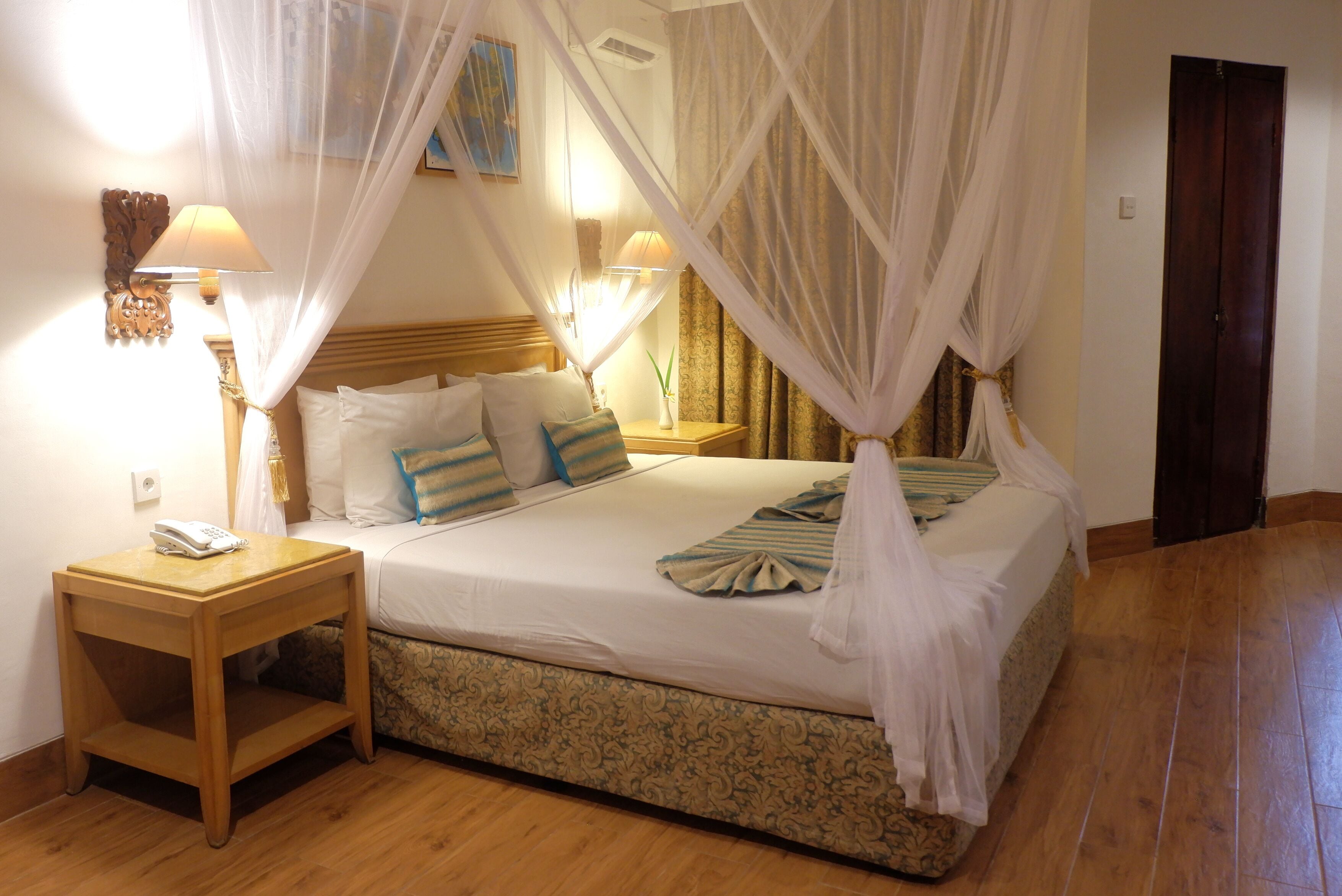 A bedroom with a bed, bedside tables, and a canopy bed.