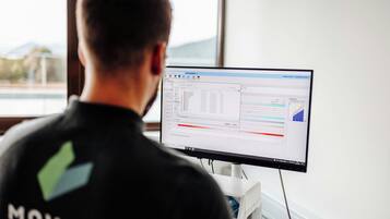Una persona trabajando en una computadora con una ventana al fondo.
