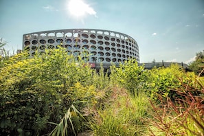 A modern building with a circular design and multiple openings.