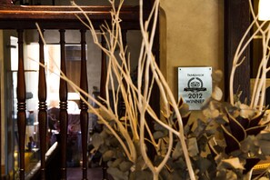 A wooden staircase with a TripAdvisor award sign on the wall.