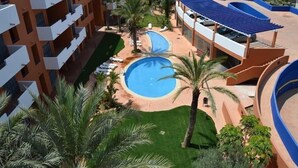 A hotel with multiple balconies, a swimming pool, and a covered area with seating. - Parque Tropical (Vera)
