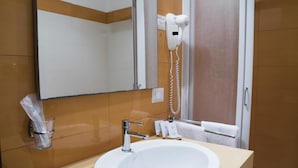 A bathroom with a white sink, a mirror, a hairdryer mounted on the wall, and a towel rack. - Hotel Catania Town (Catania)