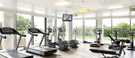 Un gimnasio moderno con cintas de correr, elípticas y pesas.
