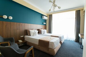 Twin Room | Minibar, in-room safe, individually decorated, desk