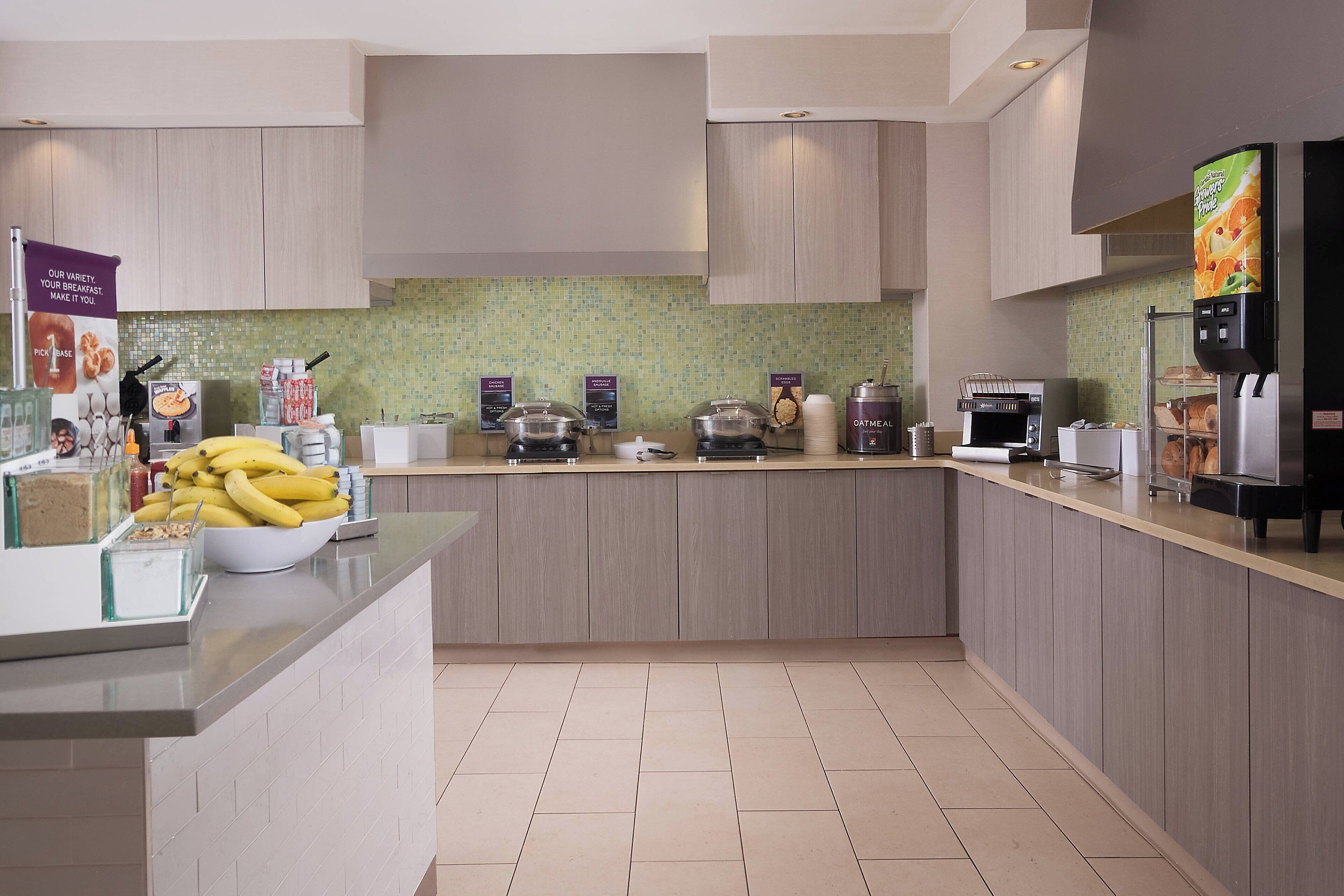 Una cocina moderna con una isla central, varios electrodomésticos y un salpicadero de azulejos.