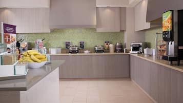 Una cocina moderna con una isla central, varios electrodomésticos y un salpicadero de azulejos.
