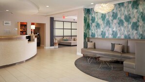 A hotel lobby with a reception desk, seating area, and a large window. - Residence Inn by Marriott Fort Myers Sanibel (Fort Myers)