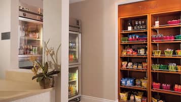 A hotel room with a minibar, a refrigerator, and a snack bar.