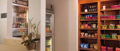 Habitación de hotel con minibar, refrigerador y bar de aperitivos.