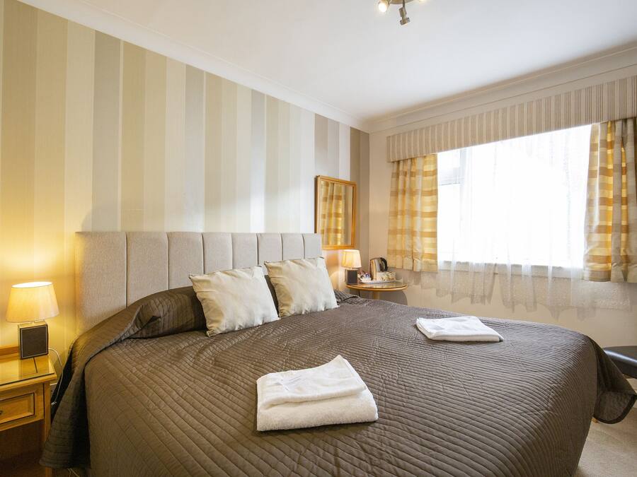 Escritorio, cortinas blackout y tabla de planchar con plancha