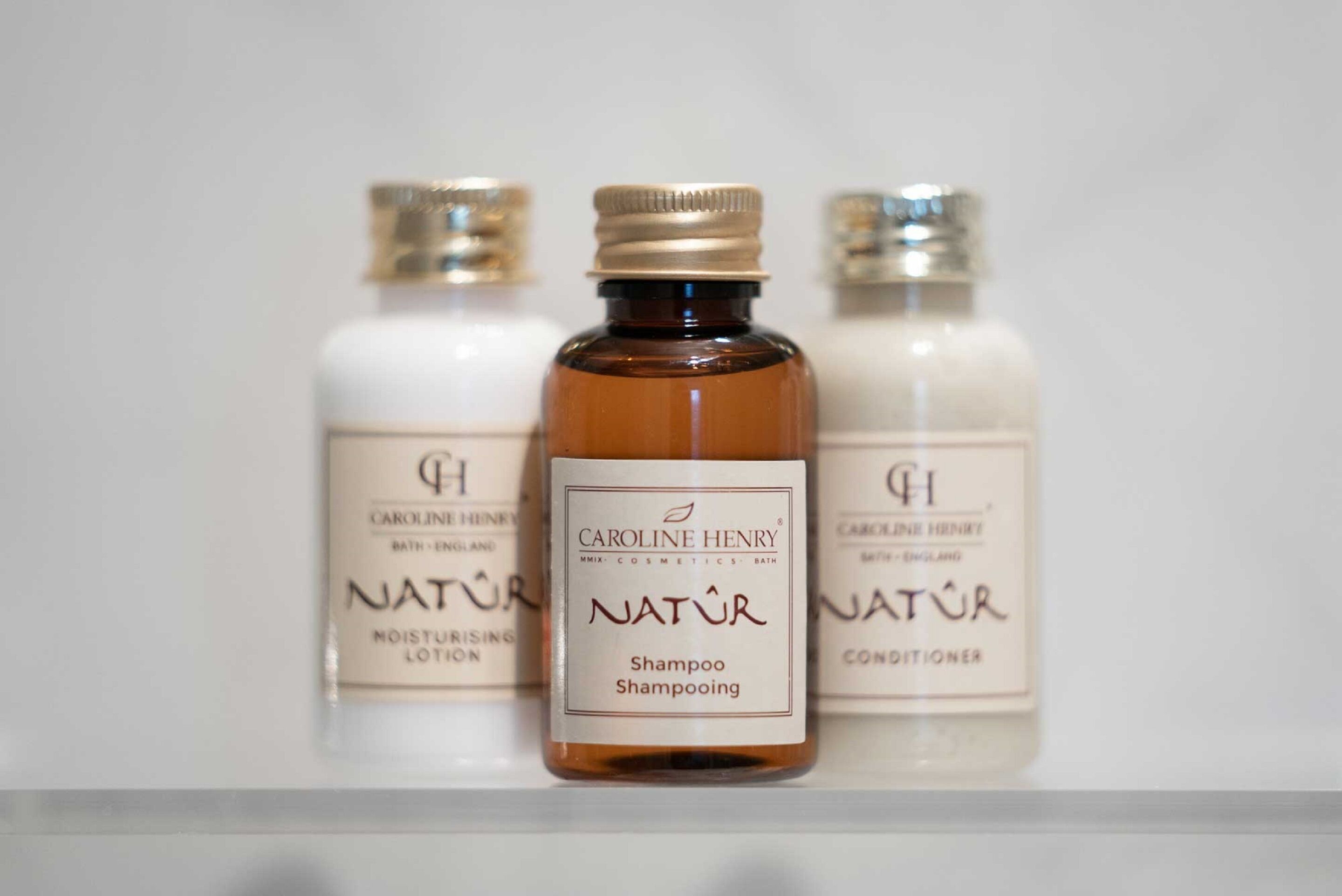 Three bottles of Caroline Henry Natur products on a shelf.