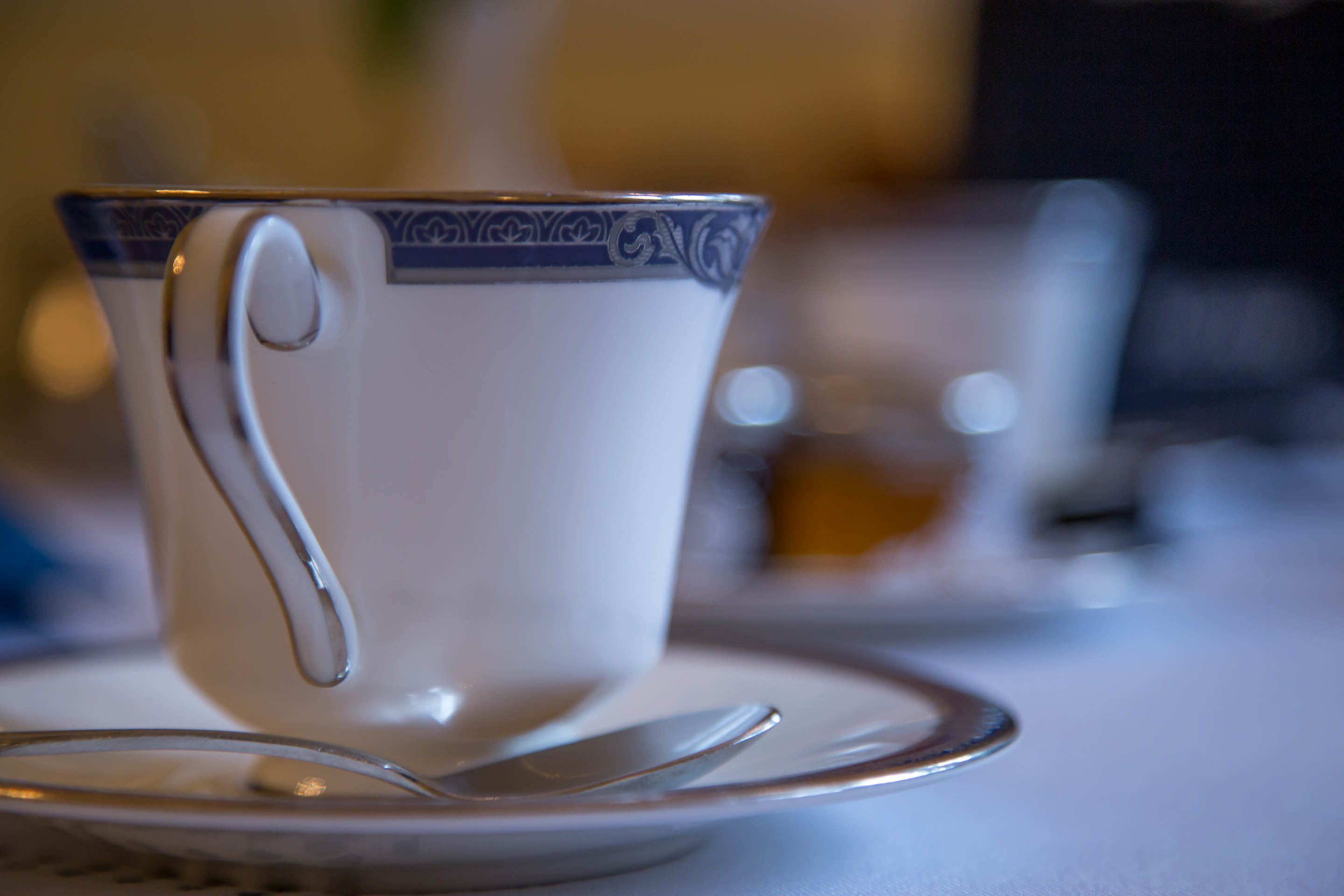 A cup with a handle on a saucer, placed on a table.