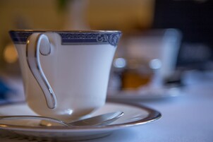 A cup with a handle on a saucer, placed on a table.