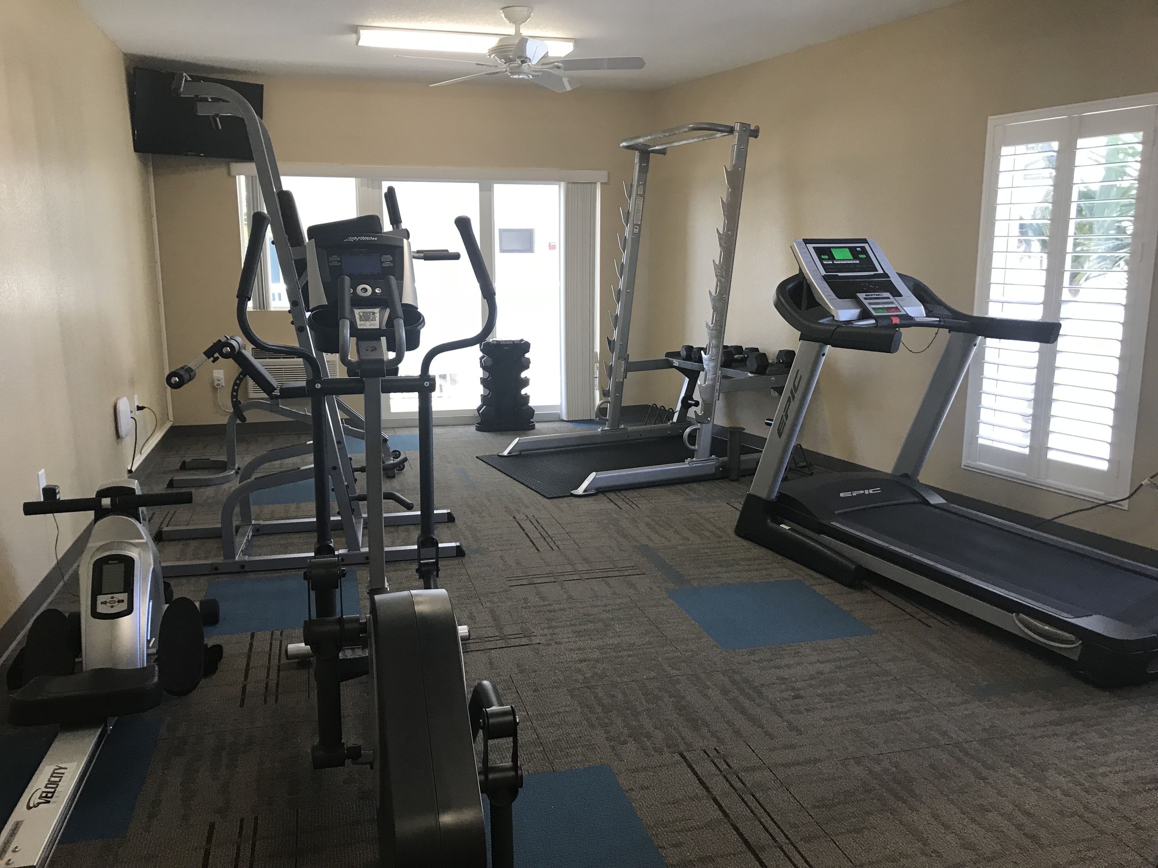 A gym with cardio machines, weight equipment, and a treadmill.
