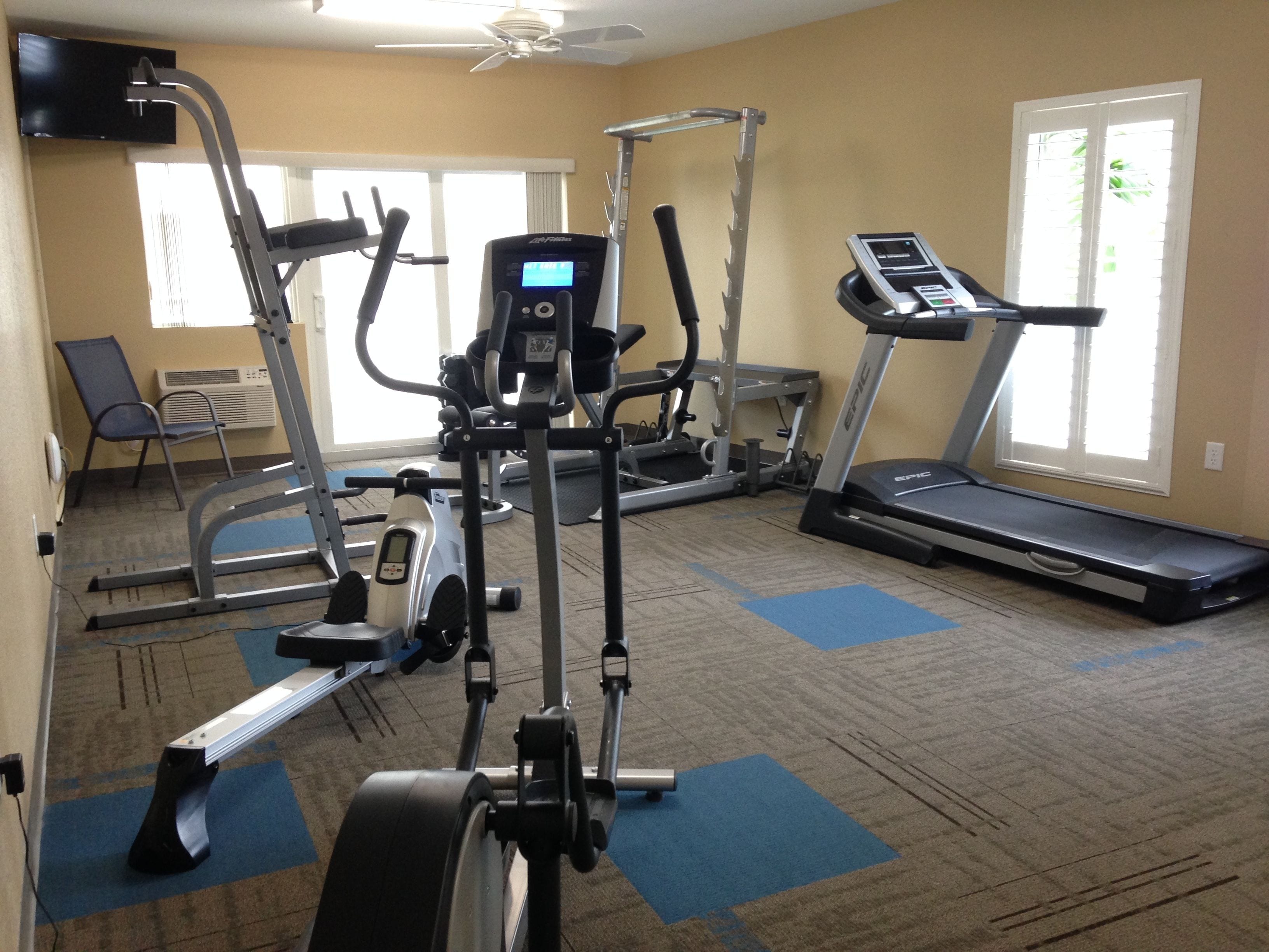 A gym with cardio machines, weight equipment, and a treadmill.