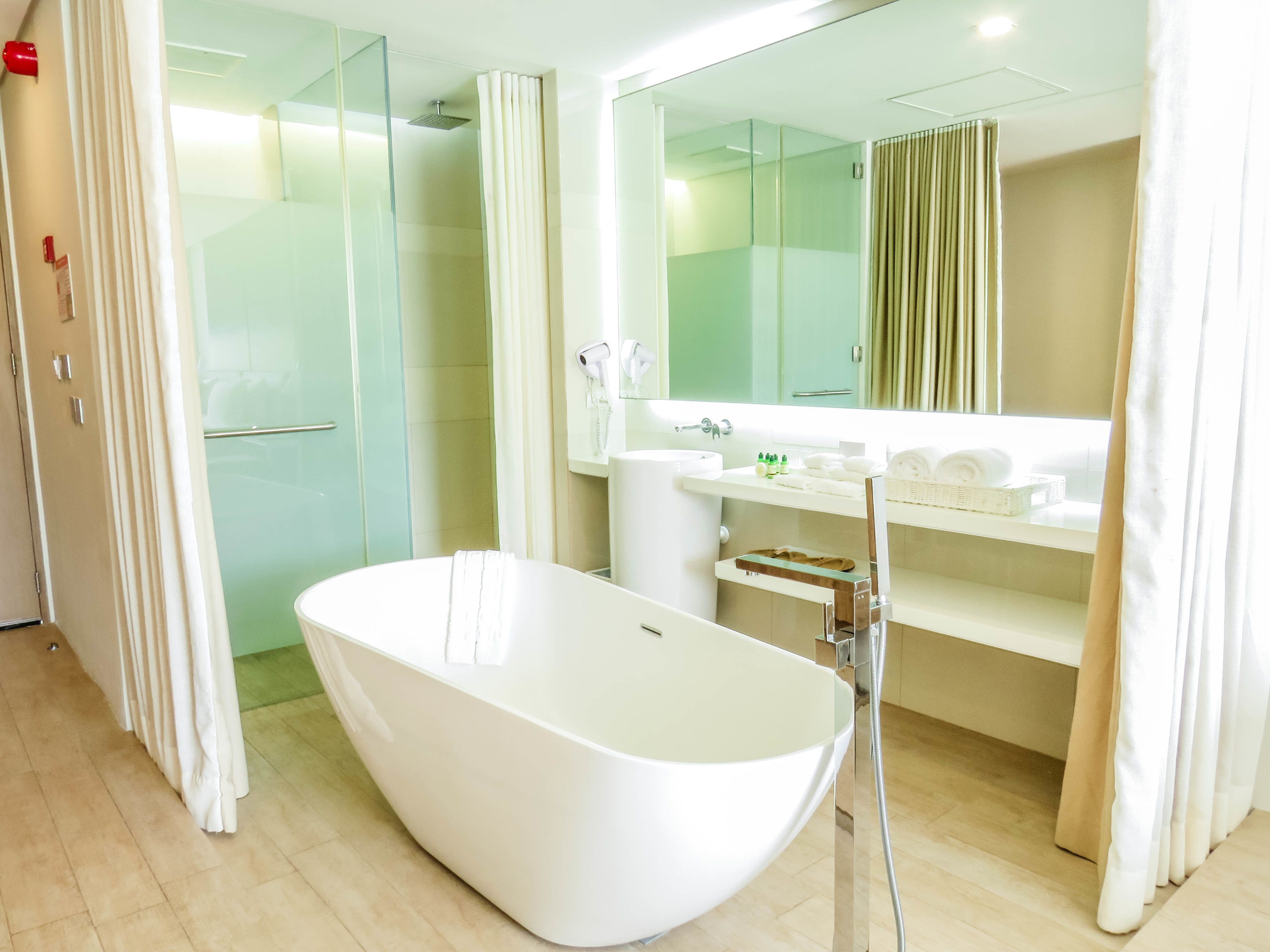 Un baño moderno con una bañera independiente, cabina de ducha de vidrio y un tocador con espejo.