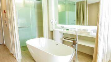 Un baño moderno con una bañera independiente, cabina de ducha de vidrio y un tocador con espejo.