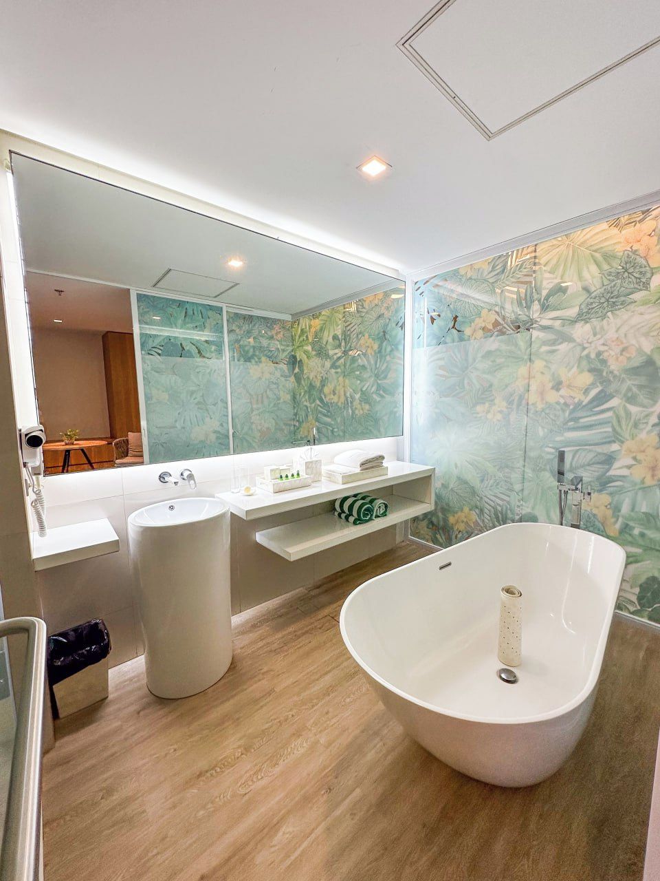 A modern bathroom with a freestanding bathtub, a double sink vanity, and a large mirror.