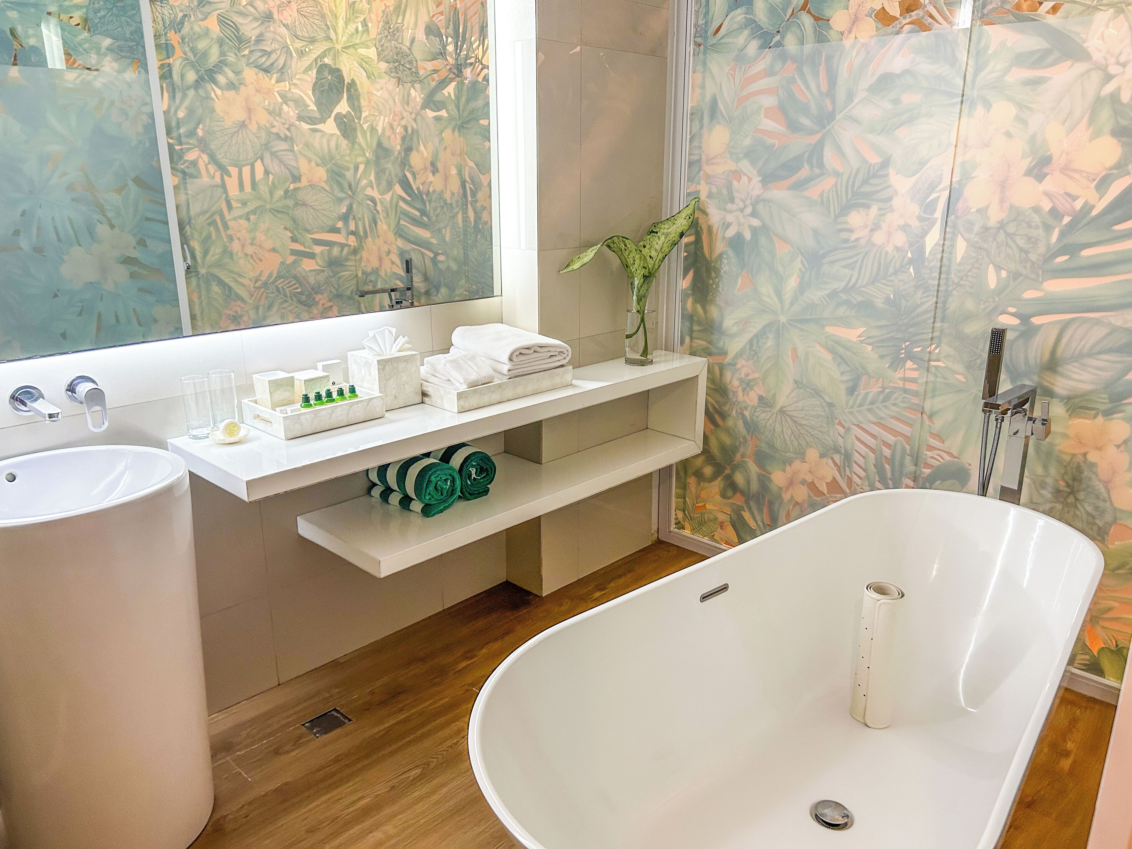 Une salle de bain moderne avec une baignoire sur pieds, un meuble-lavabo avec un miroir et un espace douche.