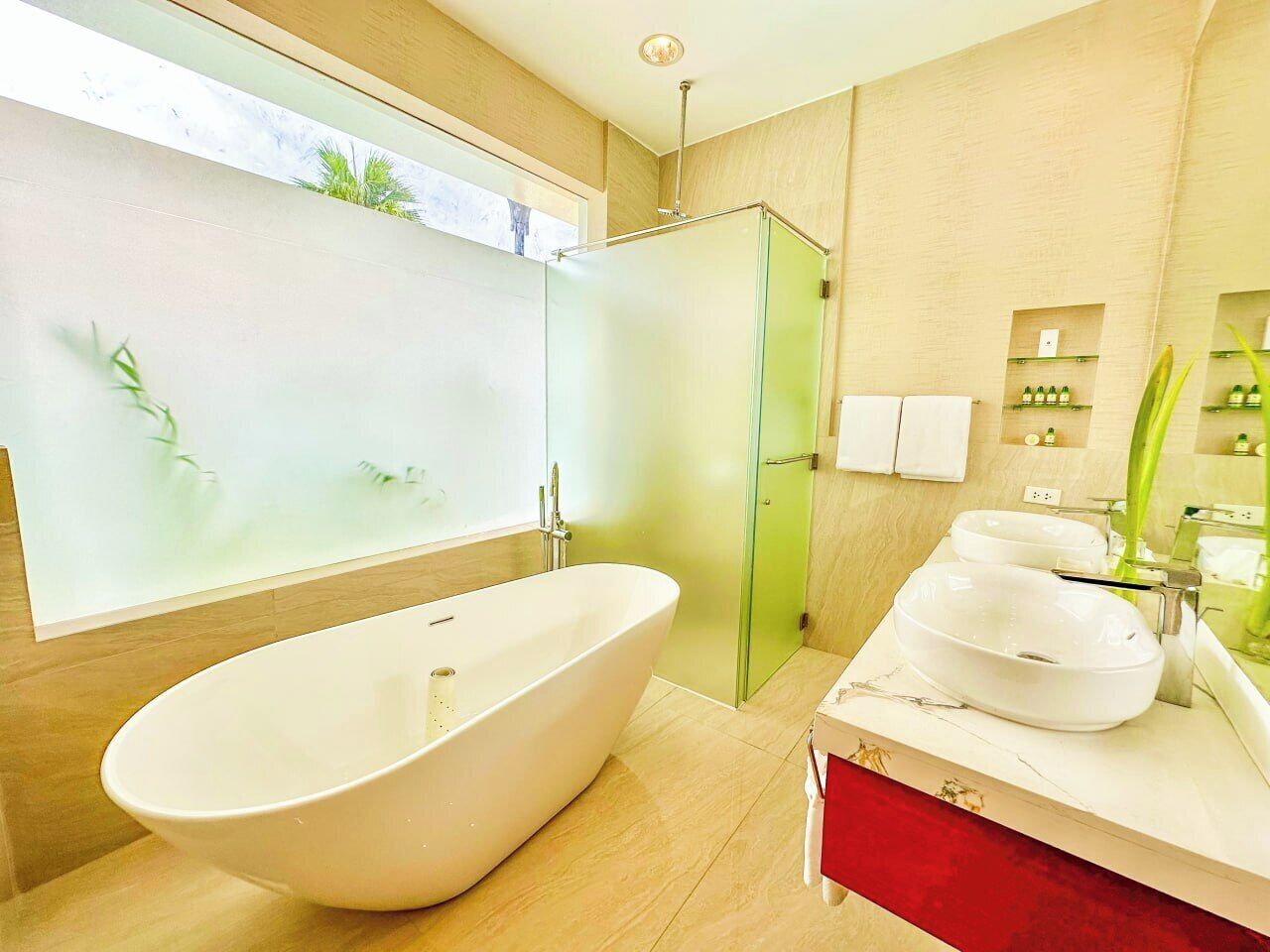 A modern bathroom with a freestanding bathtub, a glass-enclosed shower, and a vanity with two sinks.
