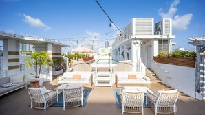 A rooftop terrace with outdoor seating, a pool, and a staircase leading to an upper level. - The Local House (Miami Beach)