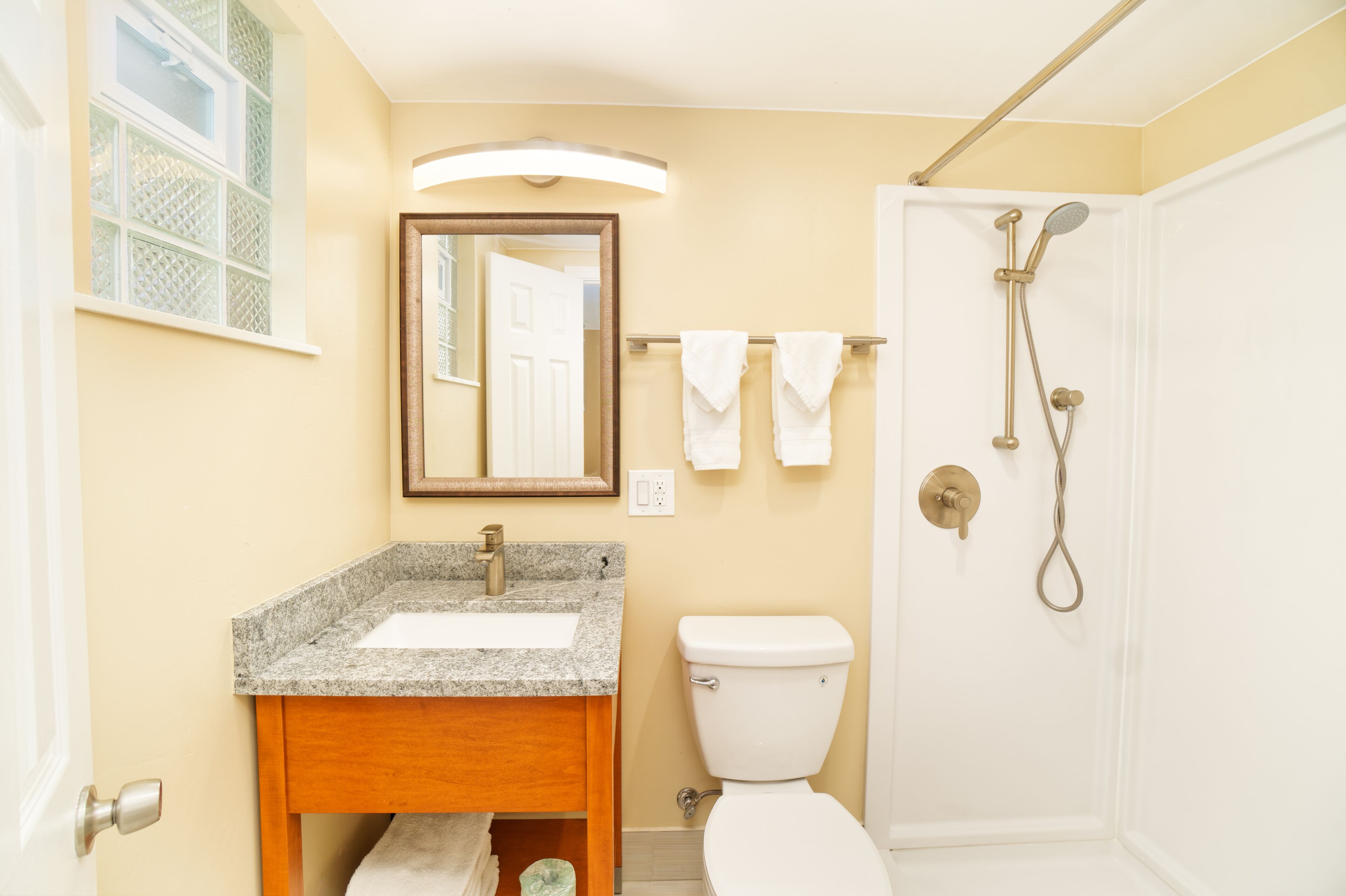 A bathroom with a sink, toilet, and shower.