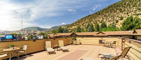 Terraza en la azotea con mobiliario exterior y vistas a un paisaje montañoso.