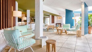 A spacious lobby with a mix of seating areas, including a sofa and chairs, a coffee table, and a small side table. - Paradou Mediterranee, BW Signature Collection (Sausset-les-Pins)