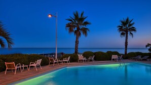 A pool area with lounge chairs and palm trees, overlooking the sea. - Paradou Mediterranee, BW Signature Collection (Sausset-les-Pins)