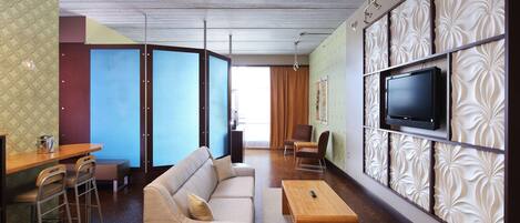 A modern living room with a sofa, coffee table, and TV mounted on a decorative wall.