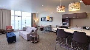 Een moderne hotelkamer met een zithoek, een kitchenette en een eethoek.