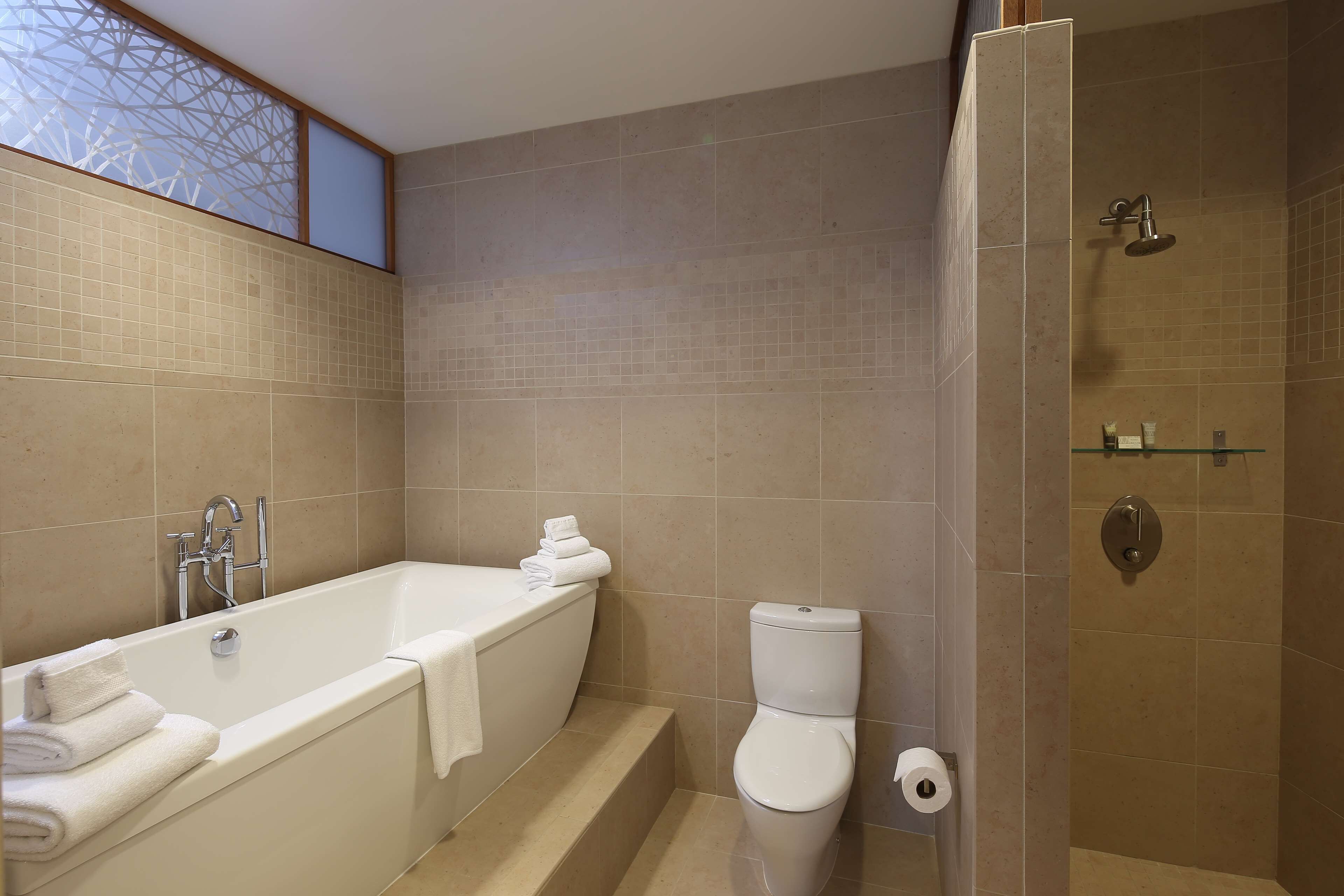 Un baño moderno con bañera, inodoro y ducha.