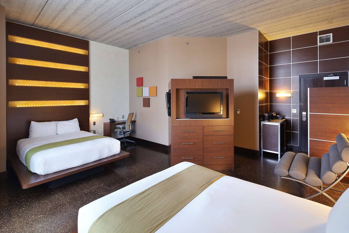Een hotelkamer met een groot bed, een bureau, een televisie en een zithoek.