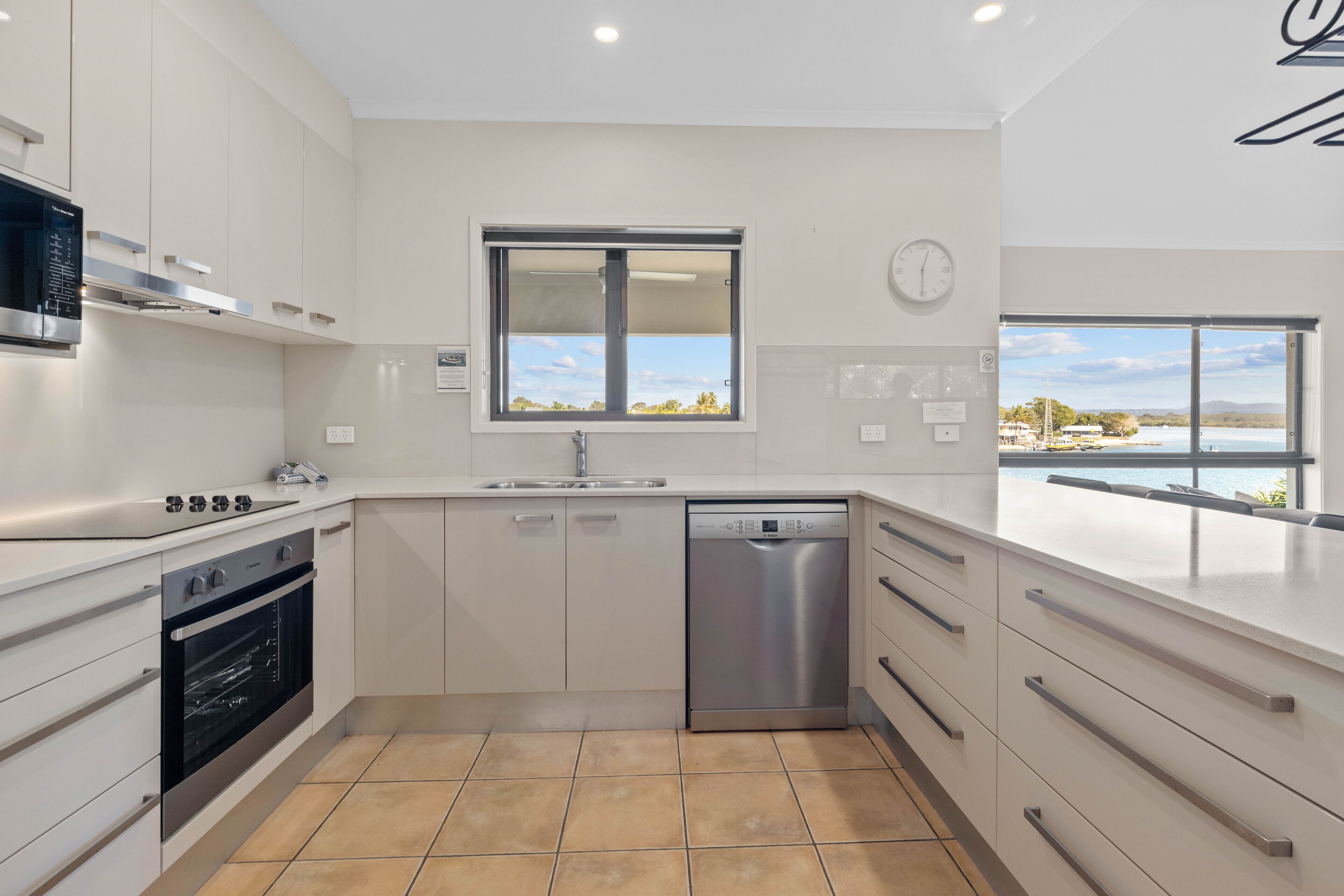 Una cocina moderna con horno integrado, lavavajillas y ventana con vistas al exterior.