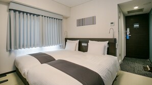 Ein Hotelzimmer mit einem großen Bett, einem Vorhangfenster, einem Kopfteil und einer Tür mit einem Schild.